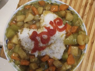 3、鸡腿咖喱饭,烧好放在装好心形的盘里  放番茄酱写上自己要写的字