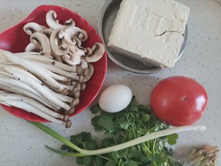 1、西红柿豆腐汤,准备食材备用，口蘑洗干净切片，蟹味菇洗干净切去根部