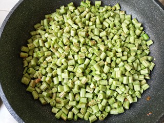 8、肉末豆角,下入豆角煸炒。