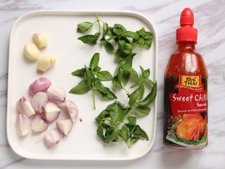 1、泰式酱烧茄子,蒜去皮切去蒂;红葱头去外皮切成小块;罗勒一把洗净备好;泰国甜辣酱备用。