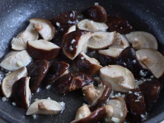 7、土豆烧香菇,锅内倒入适量植物油,放入大蒜末炒香,放入香菇翻炒出汁;