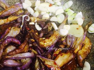11、娃娃家常菜—简单易做的鱼香茄子,翻炒几下后加入葱姜蒜继续翻炒。