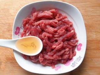 3、青椒炒牛肉丝,把切好的牛肉丝放入容器中，然后加入1汤匙料酒；