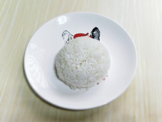 14、番茄炒蛋盖浇饭,将熟米饭装入碗中，用铲子压实，之后倒扣再盘子里，如图。