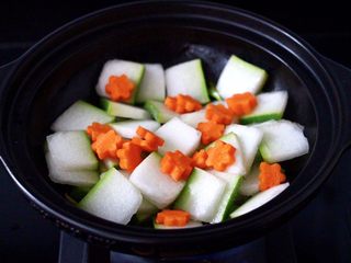 6、墨鱼丸子冬瓜木耳煲,放入冬瓜片，大火快速翻炒均匀，加入胡萝卜，继续大火翻炒片刻。