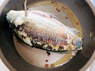 7、萝卜丝鲫鱼汤,鲫鱼翻面继续煎至，放入花椒粒爆香。