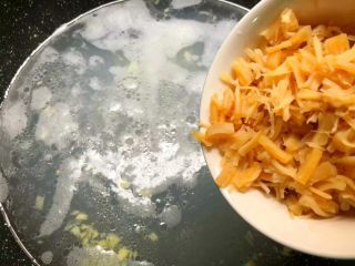6、干贝苦瓜羹,把干贝水和干贝一起倒入锅里，大火把汤煮开，加入适量盐调匀。