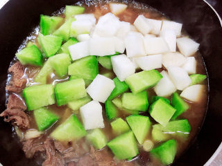 12、牛腩萝卜汤,牛腩煮开锅后，放入萝卜块，继续煮开锅。