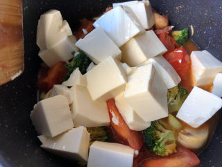 14、番茄豆腐汤,倒入豆腐块。