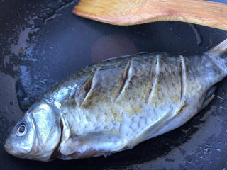 7、萝卜丝鲫鱼汤,轻轻在锅里滑动鲫鱼,让鱼受热均匀。