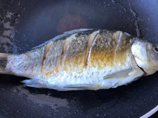 8、萝卜丝鲫鱼汤,煎制两面微微呈金黄色即可。