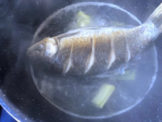 9、萝卜丝鲫鱼汤,马上倒入大碗的凉开水,放入姜片。