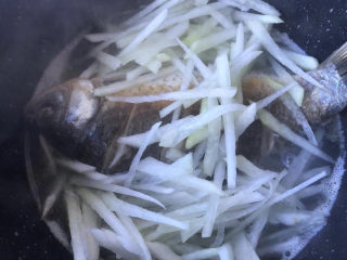 10、萝卜丝鲫鱼汤,烧开水后倒入萝卜丝。