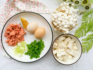 1、鲜香浓郁的菌菇豆腐汤,白玉菇200g、豆腐一块、鸡蛋2个、火腿半根、葱一根、姜适量。