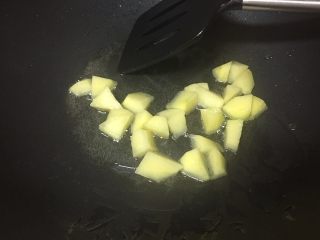 3、爱心咖喱饭,油烧热后放入土豆块。
