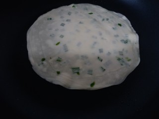 9、饺子皮版葱香酥饼,把擀好的葱香饼放锅里,小火烙饼。