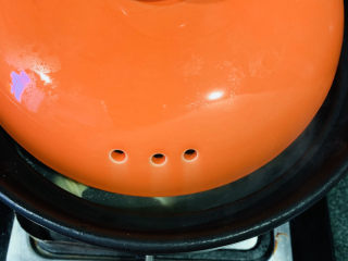 14、砂锅鱼头煲,盖上砂锅盖，注意这时砂锅盖要漏些缝，避免溢出；