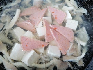 13、平菇豆腐汤,放入火腿片一起煮