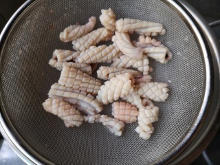 4、海鲜疙瘩汤,将鱿鱼也过水焯熟,水一开,下鱿鱼板,关火,鱿鱼打卷沥水捞出即可。