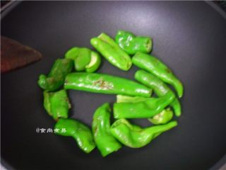 5、酱香虎皮尖椒,倒入辣椒，平铺在锅底干煸至表面起皱