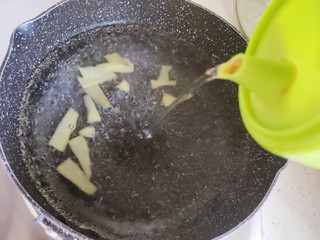 4、筒骨莲藕汤,锅内煮适量清水,水开后放入三分之二的姜片,并加适量料酒