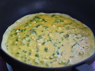 10、葱花鸡蛋饼,轻轻转动锅体，使鸡蛋面糊均匀的向锅的四周散开，摊成圆饼皮