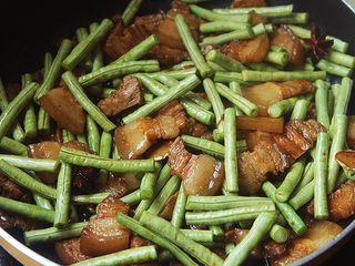 12、豆角焖肉,15分钟后把豆角倒入锅内再焖煮15分钟即可。