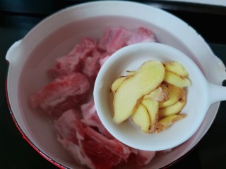 7、芋头炖排骨,再加入生姜片与料酒。