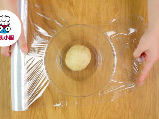 2、零难度香脆鱼皮花生,再用手揉成光滑的面团，包上保鲜膜静置醒发20分钟