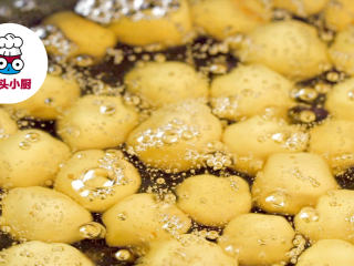 5、零难度香脆鱼皮花生,炒锅倒油烧至六成热，转小火，放入鱼皮花生，慢慢炸至金黄