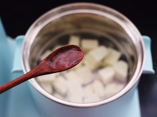 4、海蛎子豆腐汤,锅中重新倒入适量的清水,放入焯过水的豆腐,加入料酒调味。