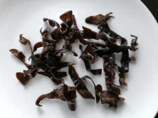 3、水煮千张,将黑木耳切成丝状