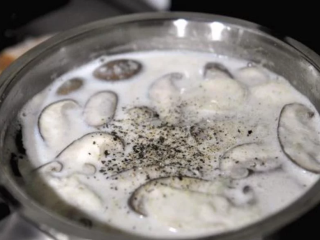 7、蘑菇浓汤,加入盐和黑胡椒调整咸度，当浓汤的表面泡泡逐渐增多就可以关火了，请避免煮到滚，以免牛奶產生油水分离的状况