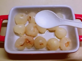 4、荔枝罐头,将荔枝果肉放入盘中 加入盐