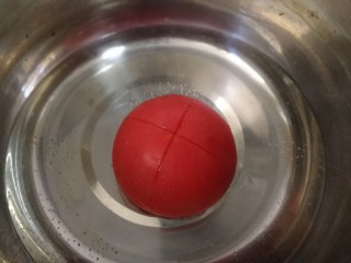 4、白玉菇鸡蛋汤,番茄洗干净,顶部切十字花刀,开水滚烫一下。