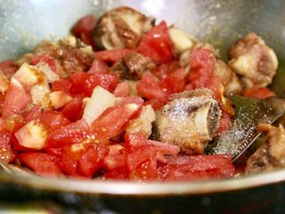 8、茄汁排骨烧虎皮蛋,放入番茄,料酒,姜片和盐,翻炒片刻