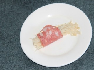 8、培根金针菇卷,把金针菇用培根卷起来，用牙签穿一下固定住
