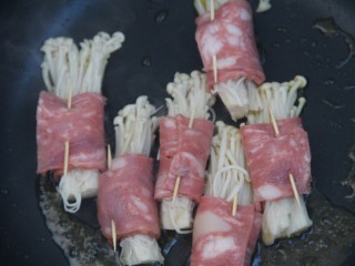 16、培根金针菇卷,把金针菇卷放进去煎