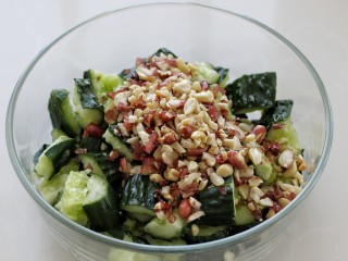 8、拍黄瓜,将黄瓜和花生碎一同放入容器中