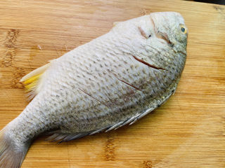 6、豆腐鱼头汤,在鱼背上轻划三刀，取少许盐涂抹鱼身腌制十分钟