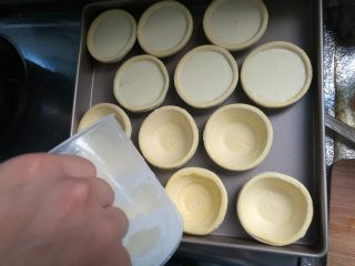 11、烘焙小白零失败的——黄桃蛋挞,搅拌均匀后倒入蛋挞皮内，每个七八分满即可。