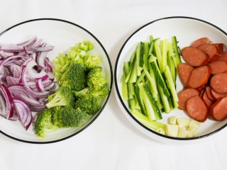 2、好吃到爆的火腿意面,香肠切斜片，西兰花撕小瓣，洋葱、黄瓜切丝，蒜切小粒。