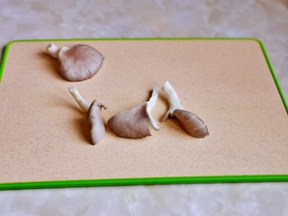2、平菇豆腐汤,首先将平菇撕小朵。