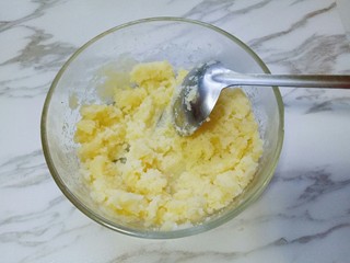 4、土豆泥芝士焗阿根廷红虾,取出蒸熟的土豆，放入大口的容器里，趁热加入黄油，少许盐，用汤勺碾成土豆泥。