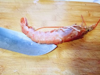 5、土豆泥芝士焗阿根廷红虾,用刀从虾的背部将虾肉切开，取出虾线，和虾头的脏物。依次做完，用冷水冲洗干净，淋干水份。