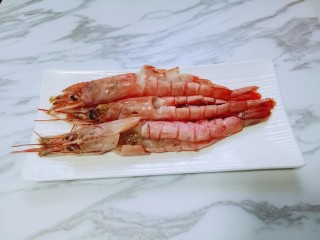 6、土豆泥芝士焗阿根廷红虾,开背的虾放入盘子里，每只虾里加入少许生抽料酒，腌制10分钟。(生抽和料酒加入开背的虾肉处。)