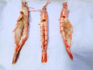 8、土豆泥芝士焗阿根廷红虾,将腌制好的阿根廷红虾放入铺有油纸的烤盘中。