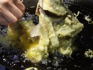 15、糖醋鱼,油烧到7-8成热,拿住鱼嘴和鱼尾弯着炸鱼,给鱼定型然后慢慢的从鱼头开始放最后放鱼尾,在油锅里炸