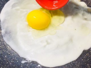 6、#最爱包子#烫面煎饼鸡蛋饼,等到表面开始凝固后，加入一个鸡蛋！
