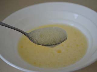 5、文蛤蒸蛋,用勺子撇去蛋液表面的浮沫。